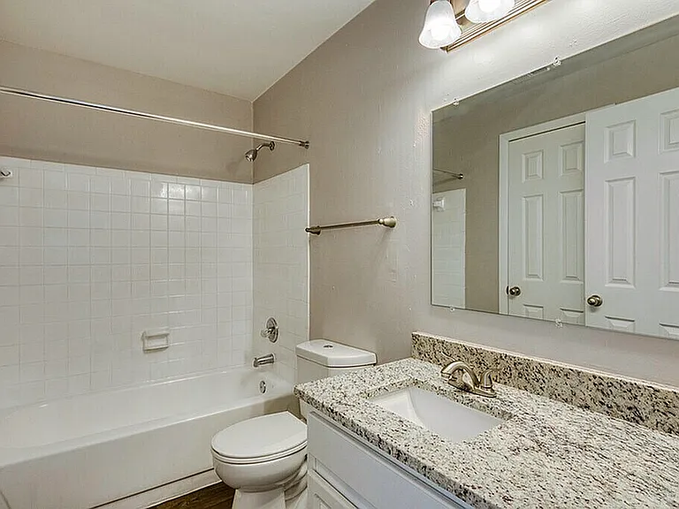 Charming bathroom with elegant granite countertop, modern fixtures, and bright lighting. Perfect blend of style and functionality.