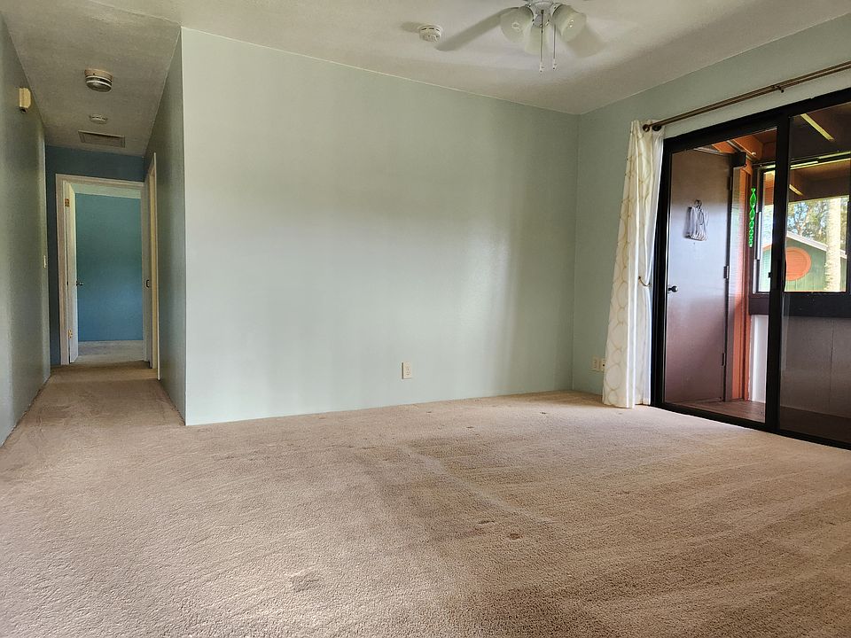 Standing at the front door looking toward the hallway that leads to the two bedrooms. Living room on the right.