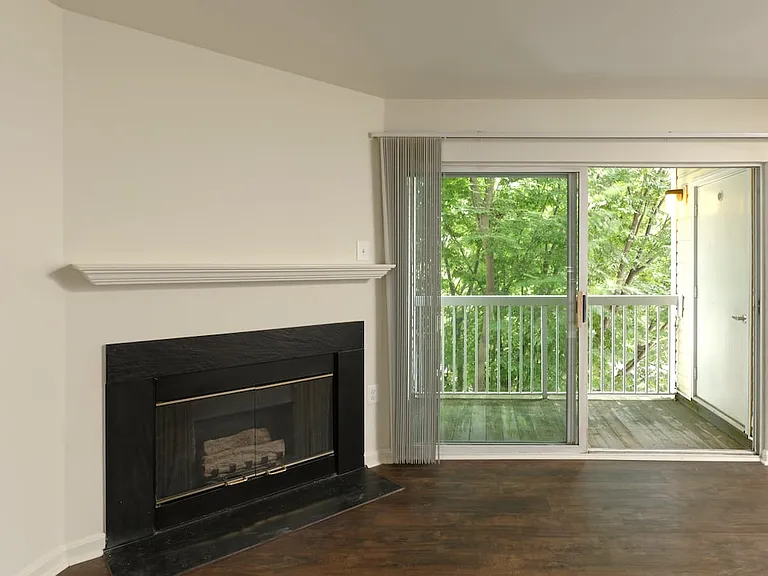 Living area with hard surface flooring, fireplace and balcony