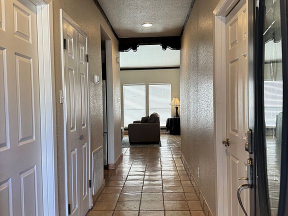 Saltillo Tile with Long Hallway. Utility room with washer and dryer located on left side of hallway
