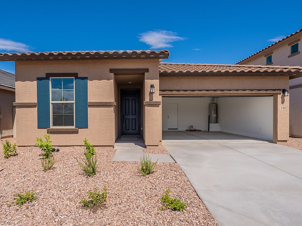 Experience elegant stucco design with a classic clay tile roof amidst serene desert landscaping in S