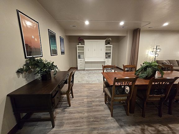 Dining table and desk, with kitchen area behind the scene.