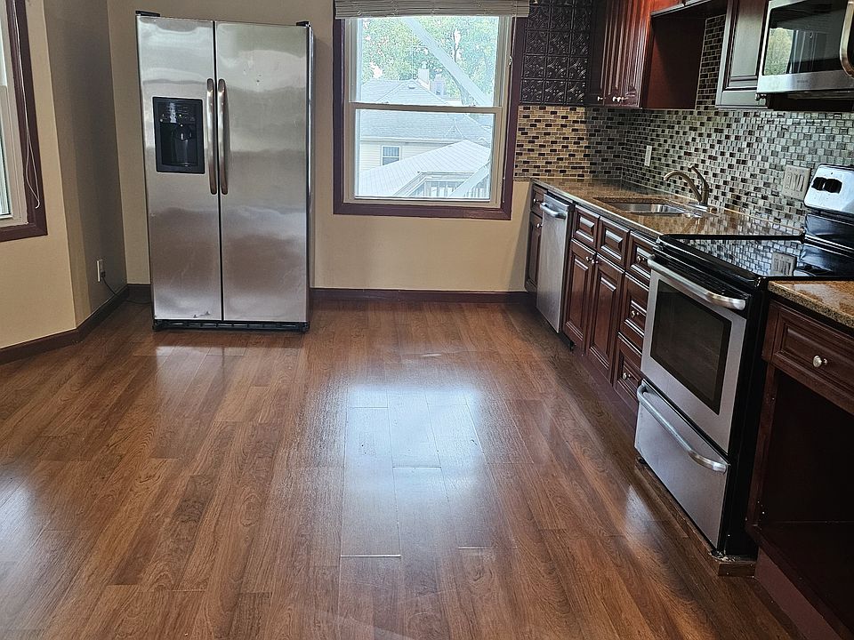 Kitchen with stainless steel appliances.
Water/ice on fridge. Well-lit.
Heavy, high-quality blinds.