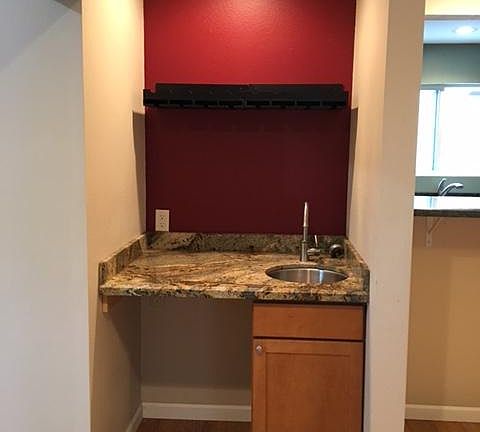 Wet bar adjacent to dining area with space for mini fridge.