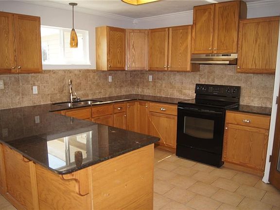 Granite countertops, stainless fixtures and large pantry. Large space for dining table with French doors leading to back of property and concrete patio.