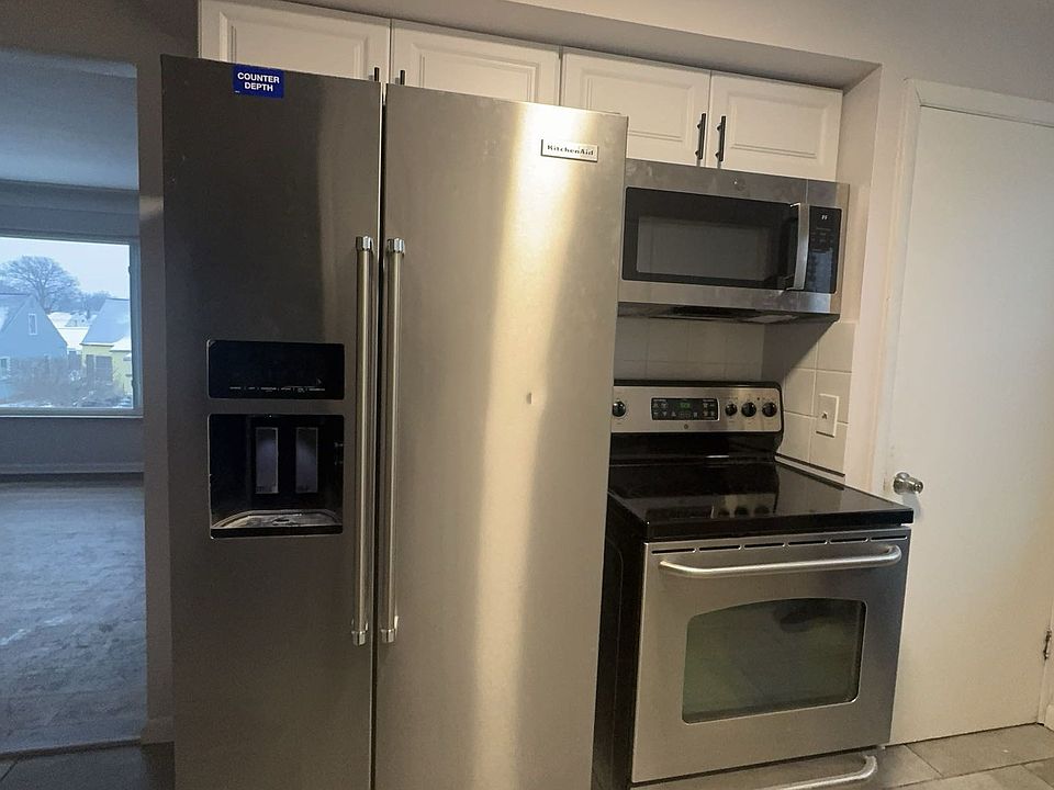 Open concept kitchen with modern quartz countertop and modern farmhouse feel and styling. Stainless Steel Fridge, Stove, Microwave & Dishwasher