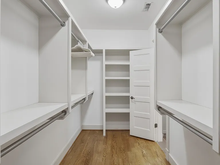 The primary suite features a king-sized bed, huge walk-in closet, ceiling fan, dresser, smart TV, and ensuite bathroom.
