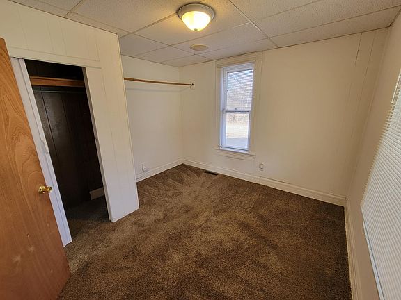 Bedroom with enclosed closet and additional closet rack