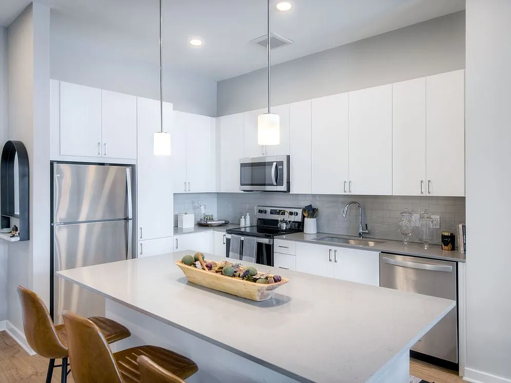 Scheme 1 kitchen with quartz countertops, tile backsplash, stainless steel appliances and hard surface flooring - Avalon Towson