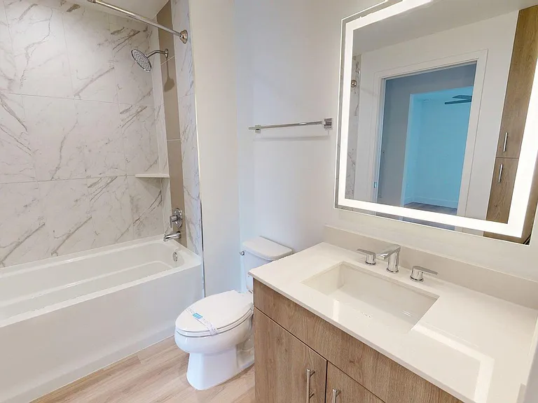 Apartment Bathroom with Single Sink , LED vanity mirror and wood-style flooring.