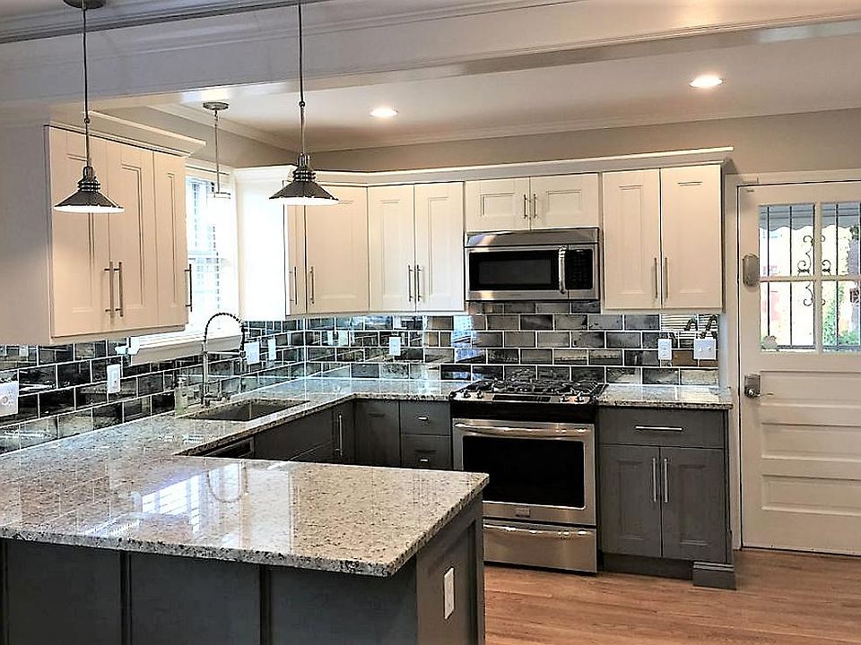 Kitchen with custom mirror backsplash and two tone cabinets. Lots of storage. Oven is gas with convection oven.