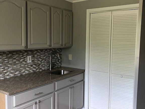 Cabinets, tile backsplash, granite counter, sink & laundry room.