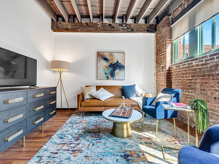 Urban Comfort: A contemporary living area combining leather, brick, and wood elements, highlighted by chic furnishing and artful decor.