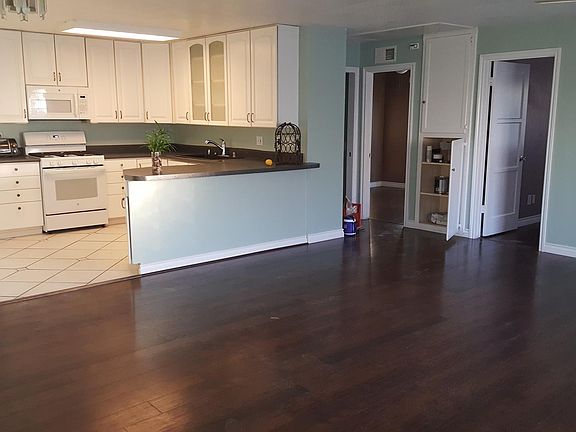 View from living room into kitchen and 2 bedrooms and hallway pantry. Bathroom just to the left of the 2nd bedroom in the picture in the hallway. Large open area to entertain friends and family.
