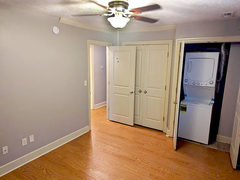 Bedroom with closet and in-unit washer and dryer at Auburn Apartments.