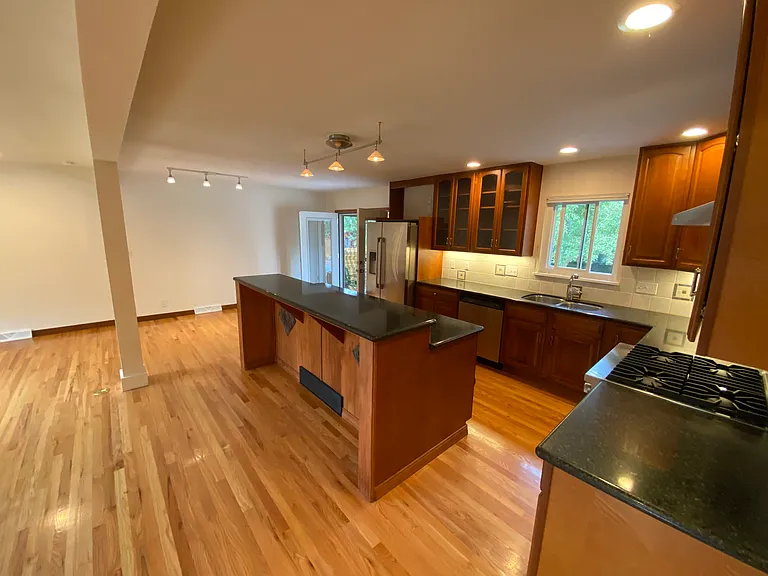 kitchen with new appliances and granite countertops, French doors opening to beautiful garden