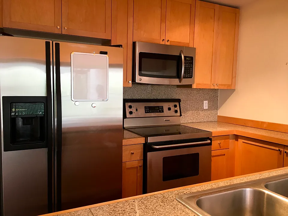 Kitchen with ample storage. Stainless steel appliances including a flat-top range and side-by-side fridge