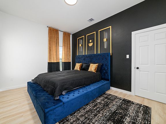 Master bedroom from closet view, Queen size bed, 55 inch smart TV, Lamp lights above bed on wall.