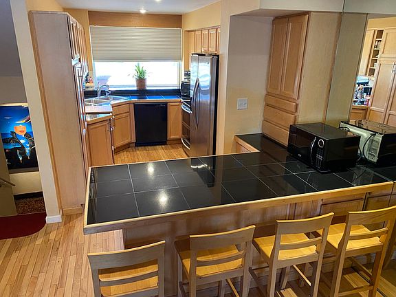 Updated kitchen, with large eat-in bar, lots of smart storage, newer appliances, and wonderful morning sunlight.