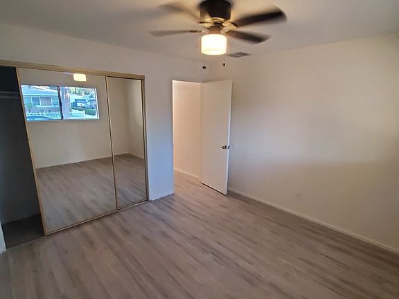 Front/master bedroom with large mirrored wardrobe doors and new lighted ceiling fan