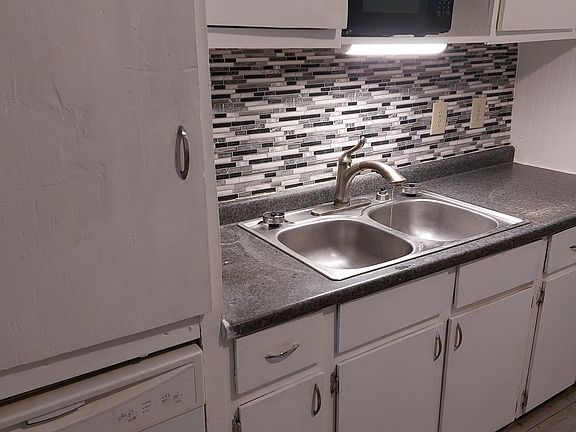 The kitchen includes a dishwasher and a small microwave oven.