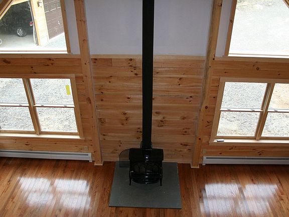 Looking down from top of stairs (living room, kitchen, and wood stove.)