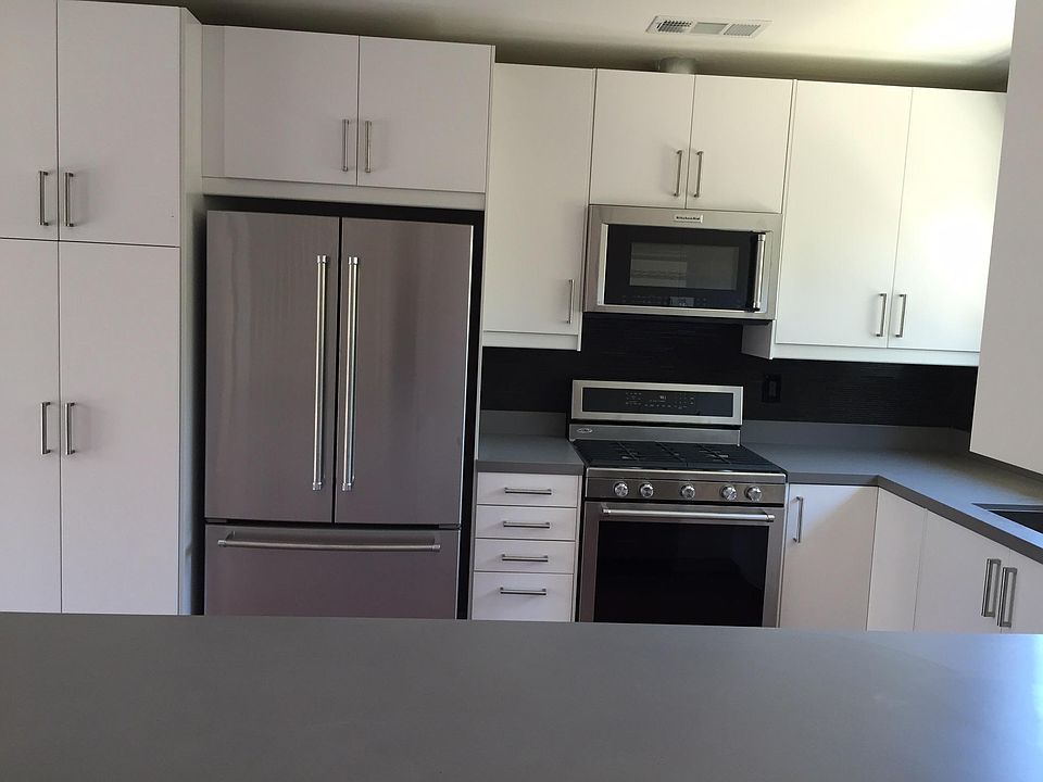 Plenty of cabinet storage and stackable washer/dryer to the left of the refrigerator.