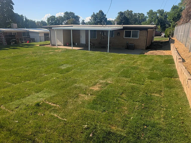 Backyard with automatic sprinklers and freshly laid sod.
