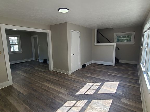 Living room, half bath, entry to dining room, stairs going up.