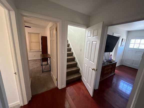 View from bedroom #1. To the immediate left is a full bathroom, straight ahead is a second bedroom, stairs lead up to master bedroom, and to the right is the living room.