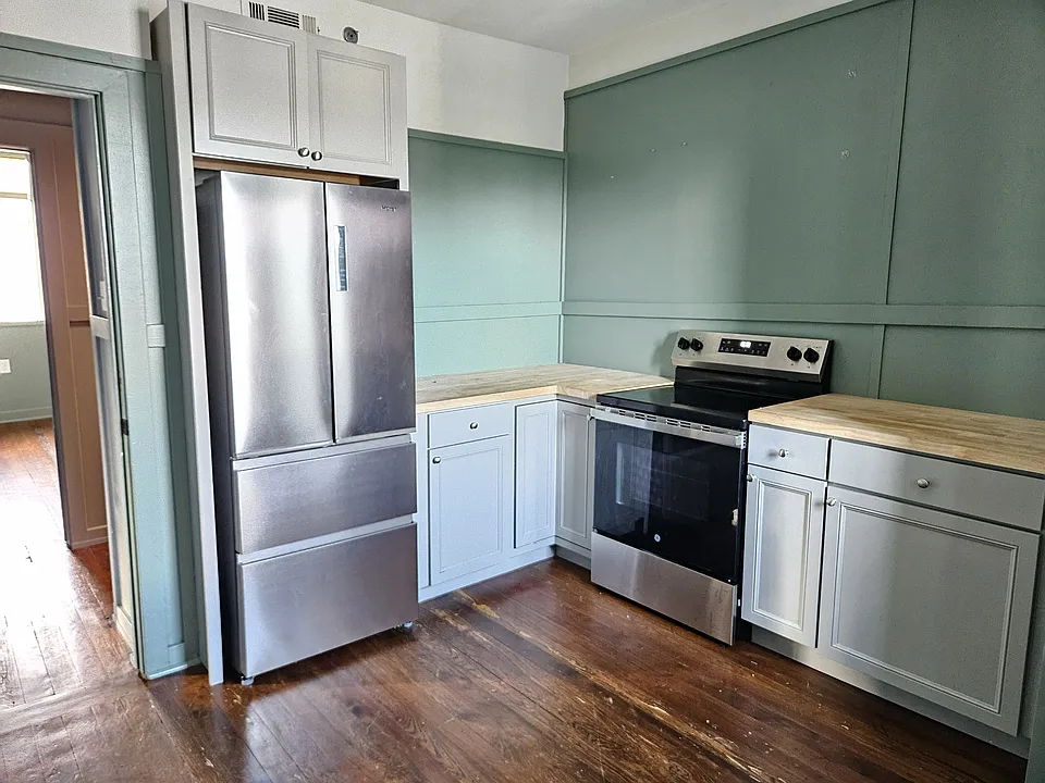 Eat in kitchen with butcher block countertops and stainless steel appliances