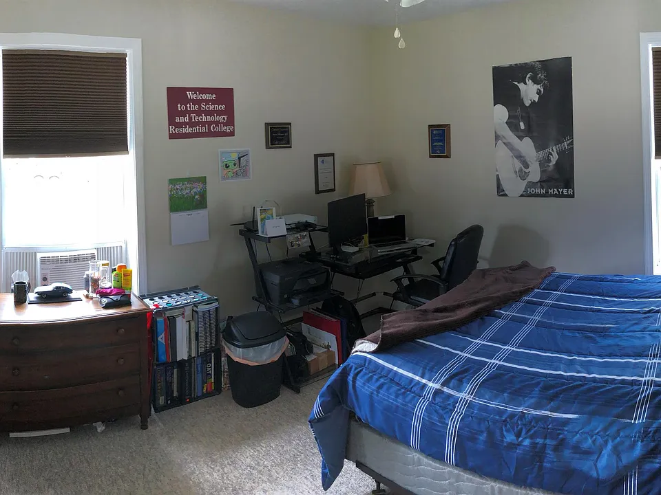 Bedroom with mirrored closet, closet organizers, ceiling fan, and room darkening shades