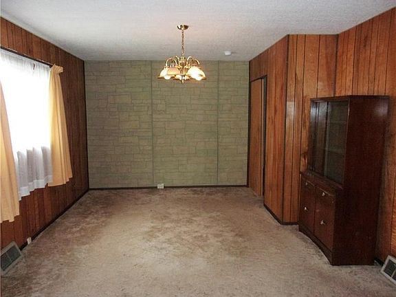 Dining room with closet and large window.