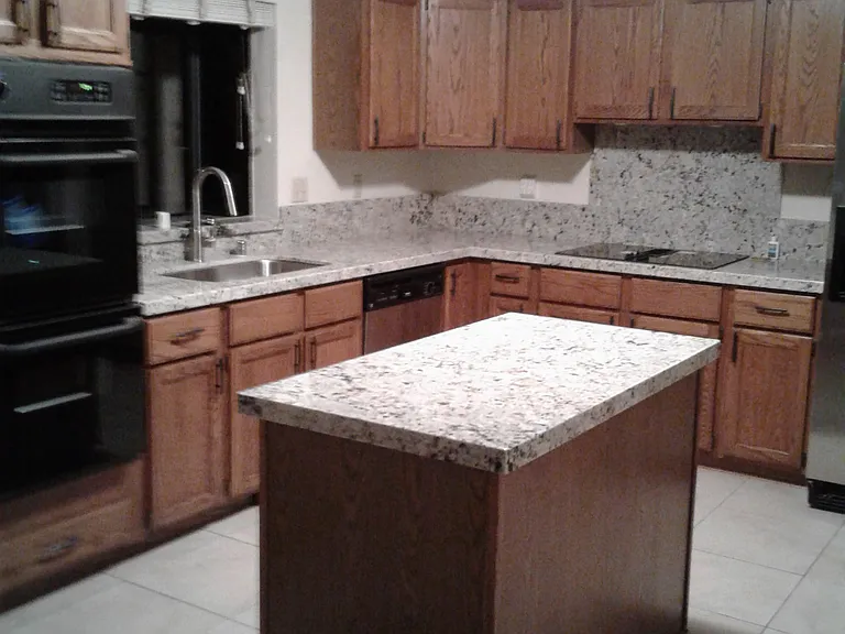 kitchen with granite counter tops, double ovens, electric downdraft cooktop