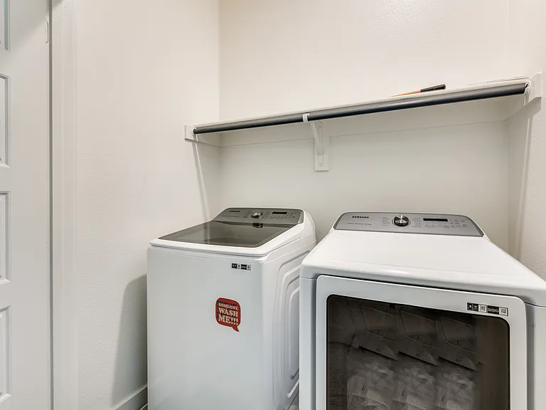 Upstairs laundry with sleek, modern washer and dryer.