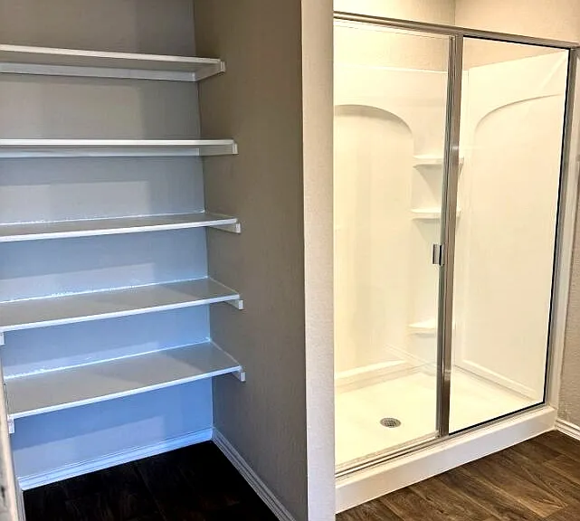 Clean and modern primary bathroom with ample space and storage.