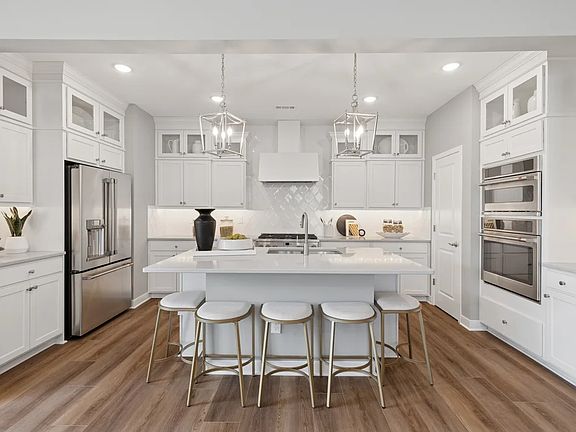 Kitchen with pendant lights and upper glass cabinets