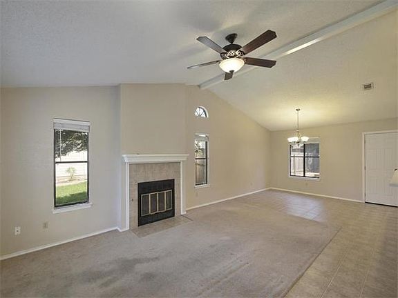 Cozy fireplace and high ceilings make the living room feel extra spacious