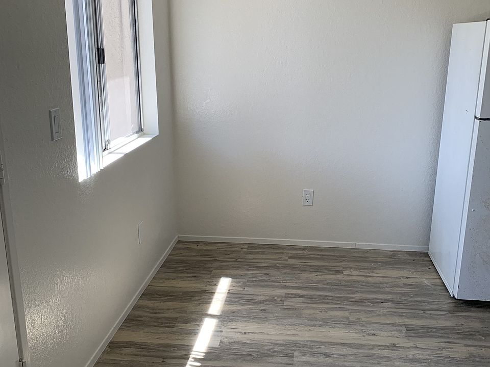 Dining area with plank style flooring, lots of natural light and ceiling fan at Carlsbad Sunset Senior Apartments in Carlsbad, California.