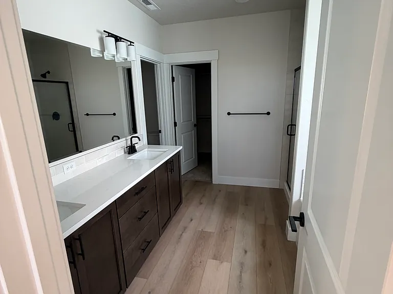 Enjoy spa-like living in the expansive primary bathroom, complete with dual vanities, a large walk-in closet, a separate glass-enclosed shower, and a deep soaking tub.