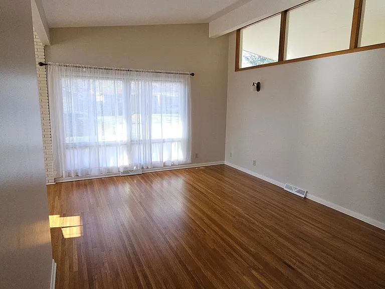 Living room showing height of ceiling and large upper windows.