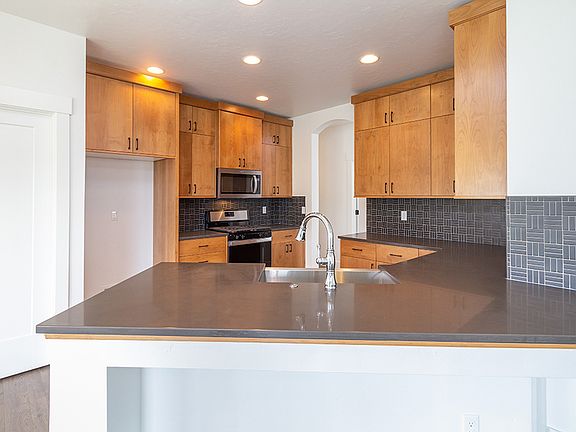 On trend kitchen with quartz, SS appliances, and a open concept