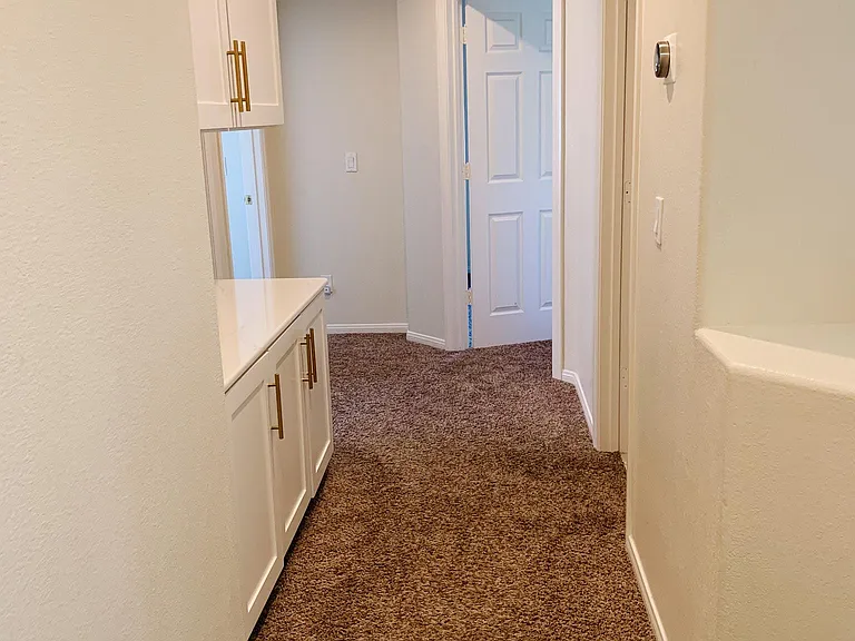 Hallway with quartz countertop and linen cabinets.