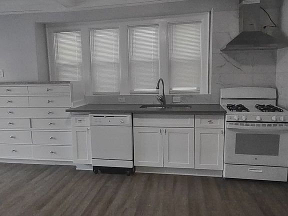 Kitchen with gas stove, dishwasher, and fridge