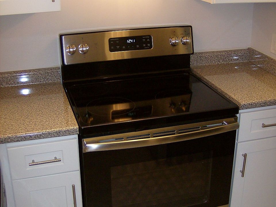 Kitchen With Stainless Stove, Hodd, Faux Granite Counters And White Cabinets