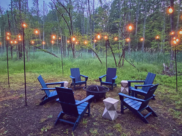 Fire pit area with lighting & modern furniture in the back yard