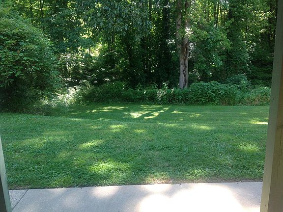 Lawn area and woods on back side of building.