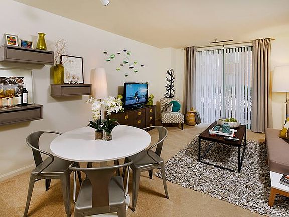 Living and dining area with carpeted floor and balcony