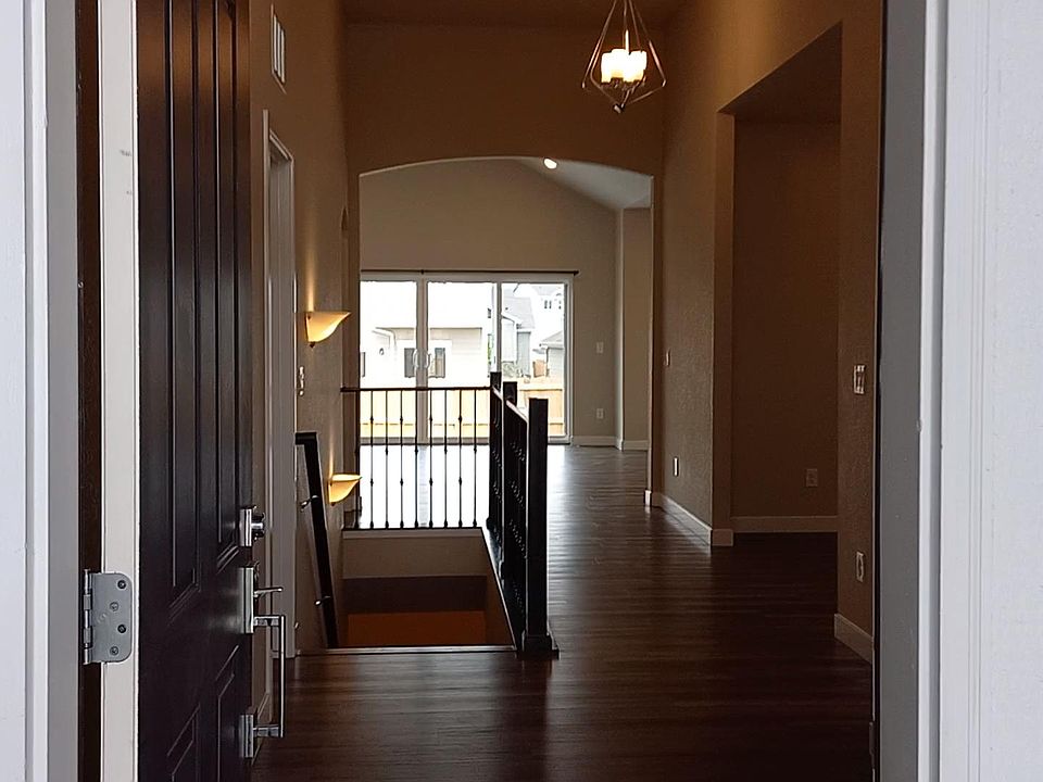 Looking through the front door from the porch, past the dining/living room, through the Great-room, out the double-wide glass patio door.