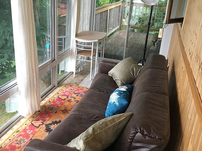Main Floor Bedroom: 3 - Season Porch with Clean but Older Couch that folds down to a bed